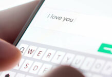 Sending I love you text message with mobile phone. Online da