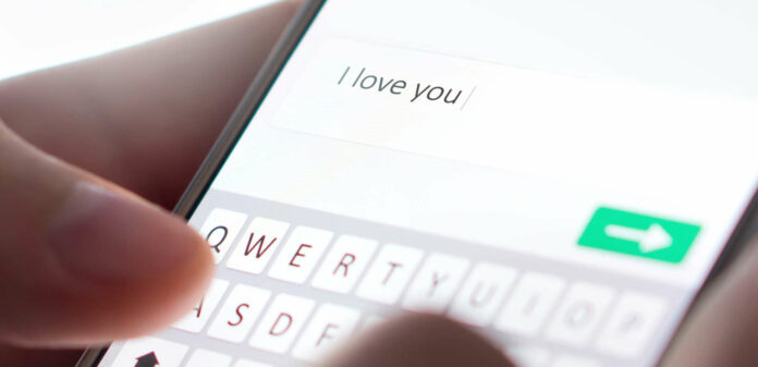 Sending I love you text message with mobile phone. Online da