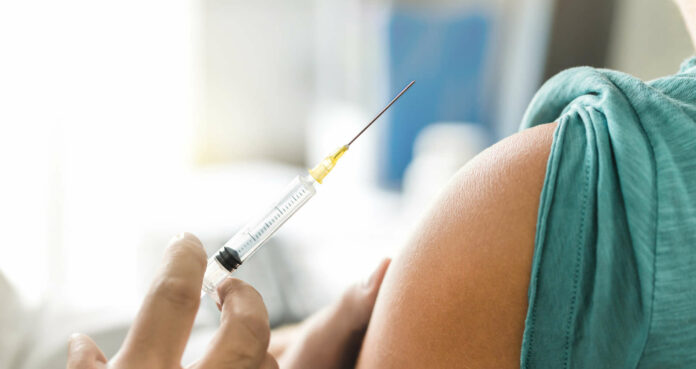 Vaccine or flu shot in injection needle. Doctor working with