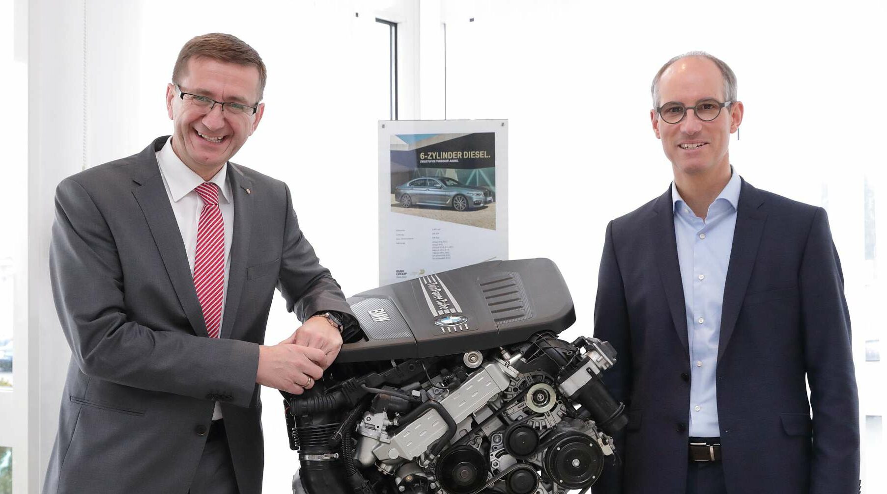 Wirtschaftslandesrat Markus Achleitner (links) und BMW-Steyr-Geschäftsführer Alexander Susanek flankieren einen hocheffizienten Dieselmotor aus Steyr.