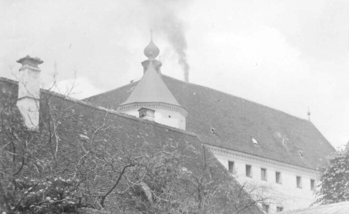 Die Euthanasie-Anstalt Schloss Hartheim mit aufsteigendem Rauch