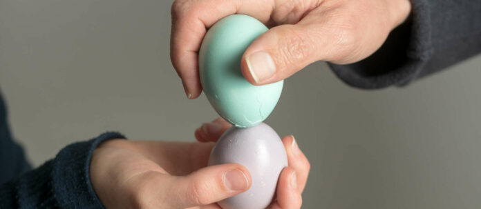 Erkek ve kadın ellerinde bir Paskalya yumurtası tutuyor, Eierpecke