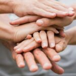 Happy volunteer family putting their hands together