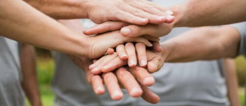 Happy volunteer family putting their hands together