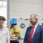 Ein Lehrling von Rosenbauer International im Gespräch mit Landeshauptmann Thomas Stelzer und CEO Sebastian Wolf.