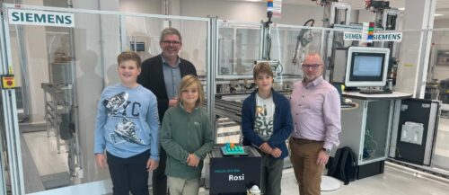 Ein Automatisierungs-Projekt im neuen „Manufacturing Solutions Lab“ von Siemens ist „Rosi“, ein fahrerloses Transportsystem. Im Bild (v. l.): Moritz, Jakob und Paul mit Günther Schallmeiner (l.) und Thomas Kagerer (r.).