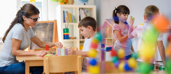Preschool teacher with children playing with colorful wooden