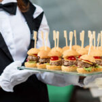 Catering service. Waiter carrying a tray of appetizers. Outd