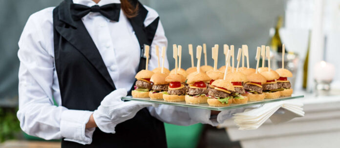 Catering service. Waiter carrying a tray of appetizers. Outd