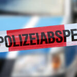 Polizeiabsperrung mit Polizeiauto im Hintergrund