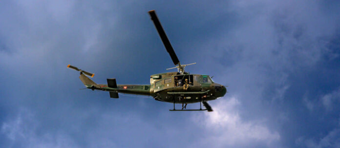 helicopter of the Austrian Armed Forces flying before a dark
