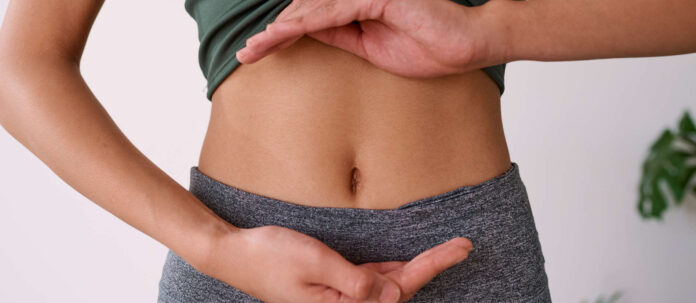 Close up of a young multi-ethnic woman's stomach cupped by h
