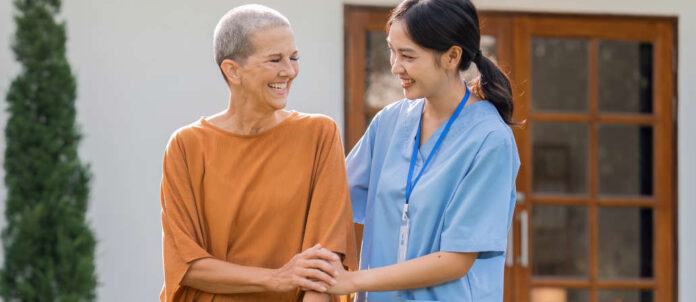 Nurse or caregiver help elderly walk by using walker in gard