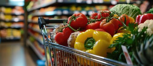 A shopping cart filled with a variety of fresh vegetables, r