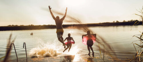 Friends having fun enjoying a summer day swimming and jumpin
