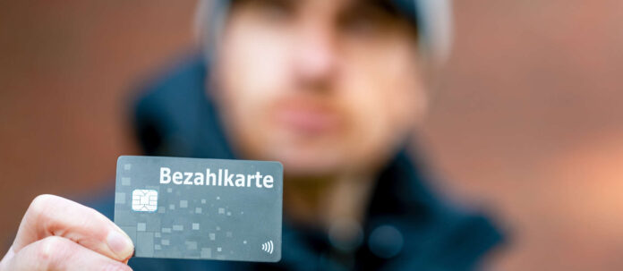 A refugee with a payment card (Bezahlkarte) in Germany. Symb