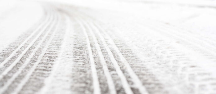 Wheel tracks on the road covered with snow