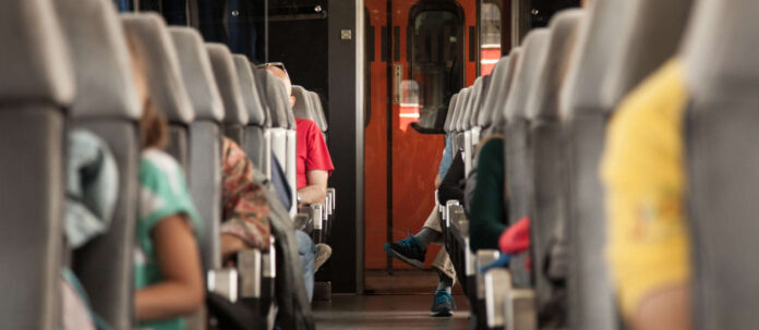 Seats of a passenger car in a European train with people sea