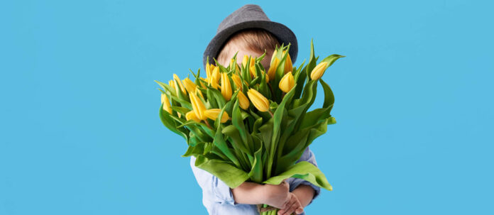 Cute smiling child holding a beautiful bouquet of yellow tul