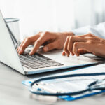 Doctor carefully review detailed medical report with laptop.