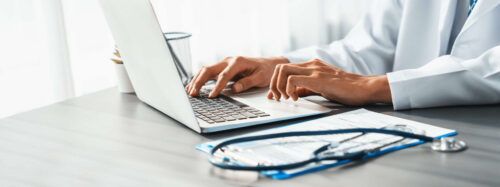 Doctor carefully review detailed medical report with laptop.